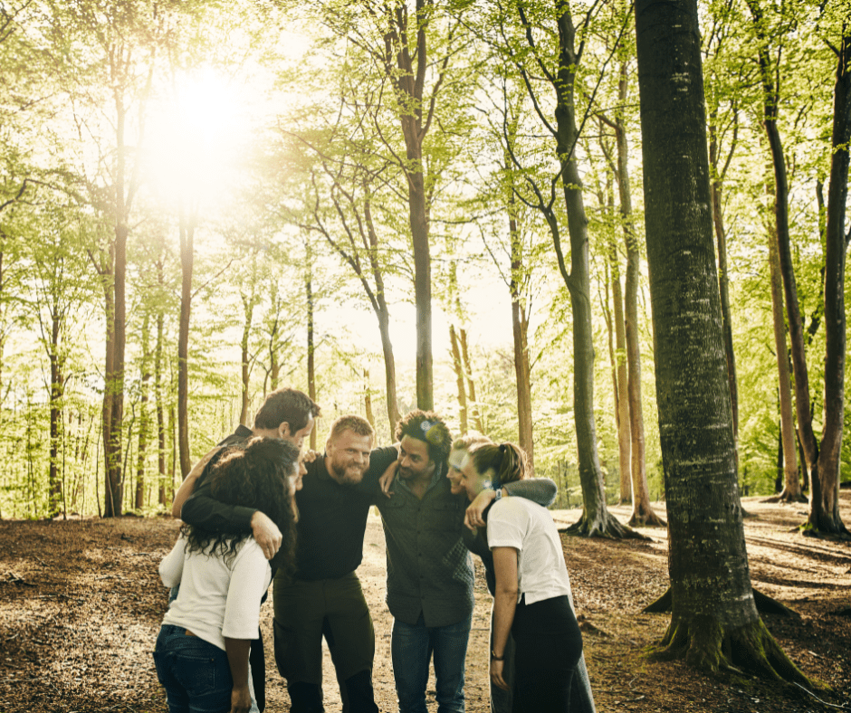 Group of people standing in a semi circle in the forest